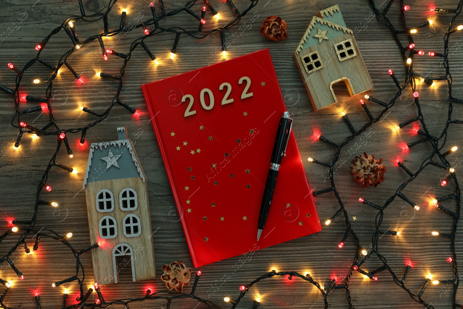 Photo of Red planner and Christmas decor on wooden background, flat lay. 2022 New Year aims