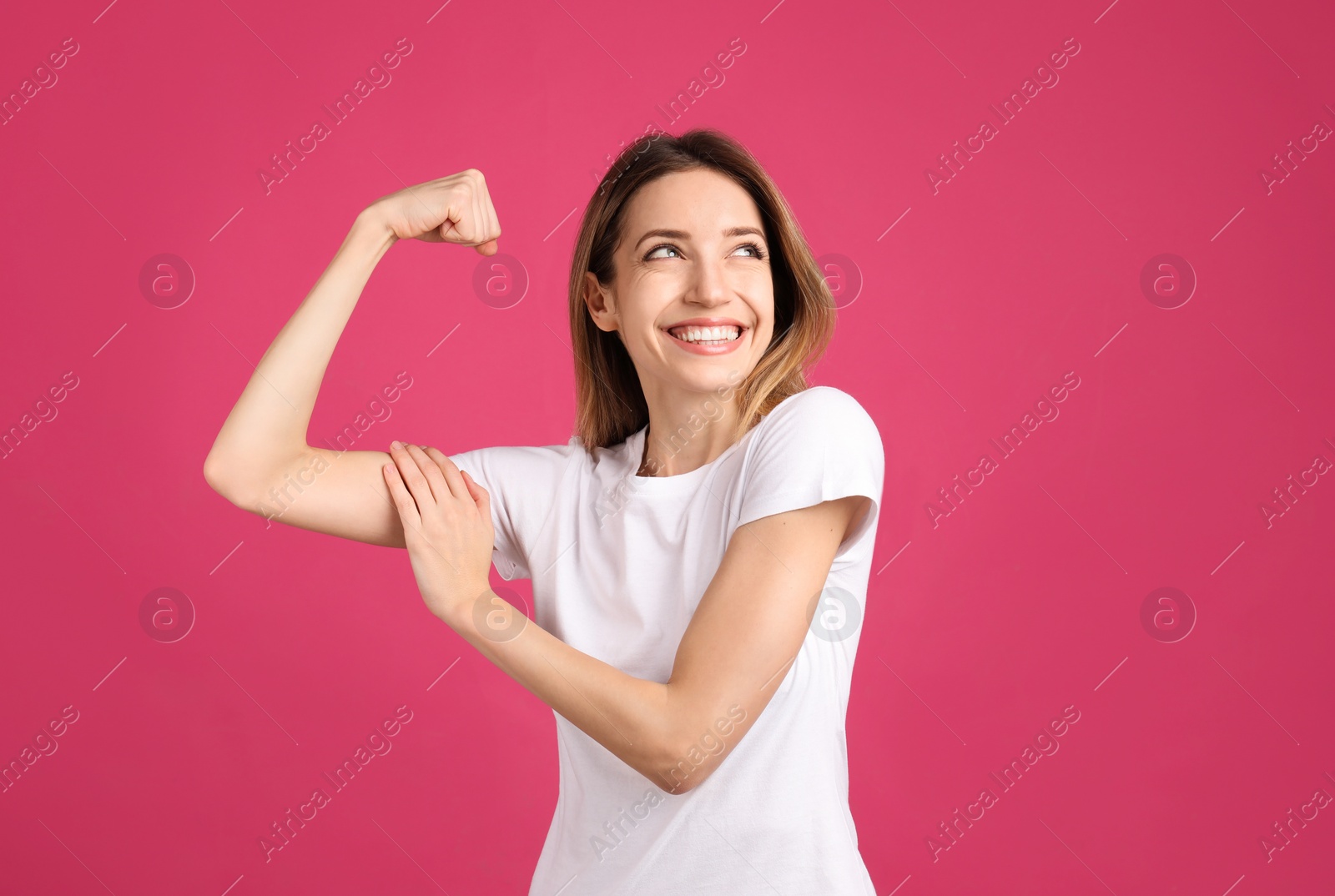 Photo of Strong woman as symbol of girl power on pink background. 8 March concept