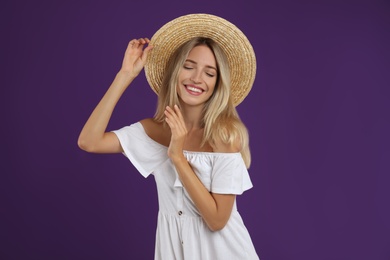 Young woman wearing stylish white dress on purple background