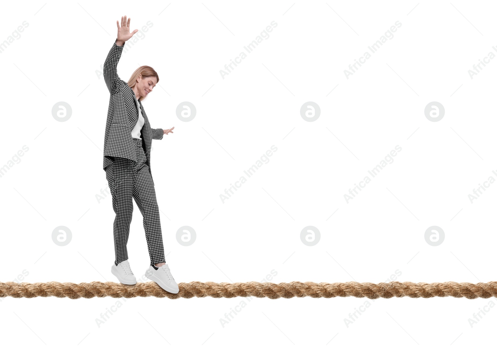 Image of Businesswoman walking rope against white background. Risk or balance concept