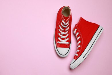 Photo of Pair of new stylish red sneakers on pink background, flat lay. Space for text