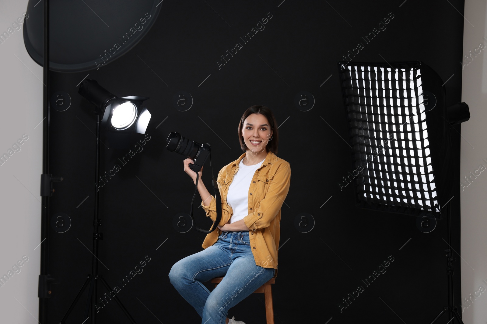 Photo of Professional photographer with camera in modern photo studio