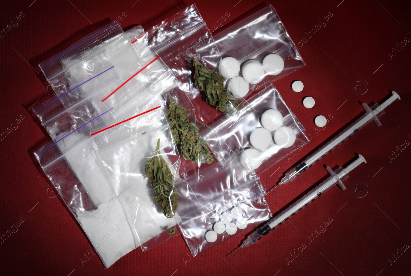 Photo of Cocaine, dried hemp and ecstasy on color background, top view