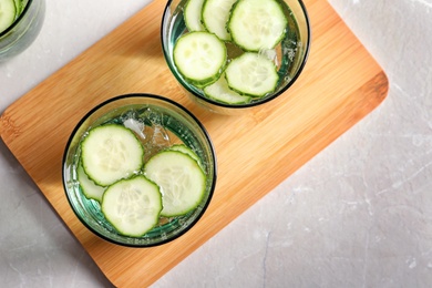 Photo of Glasses of fresh cucumber water on table, top view