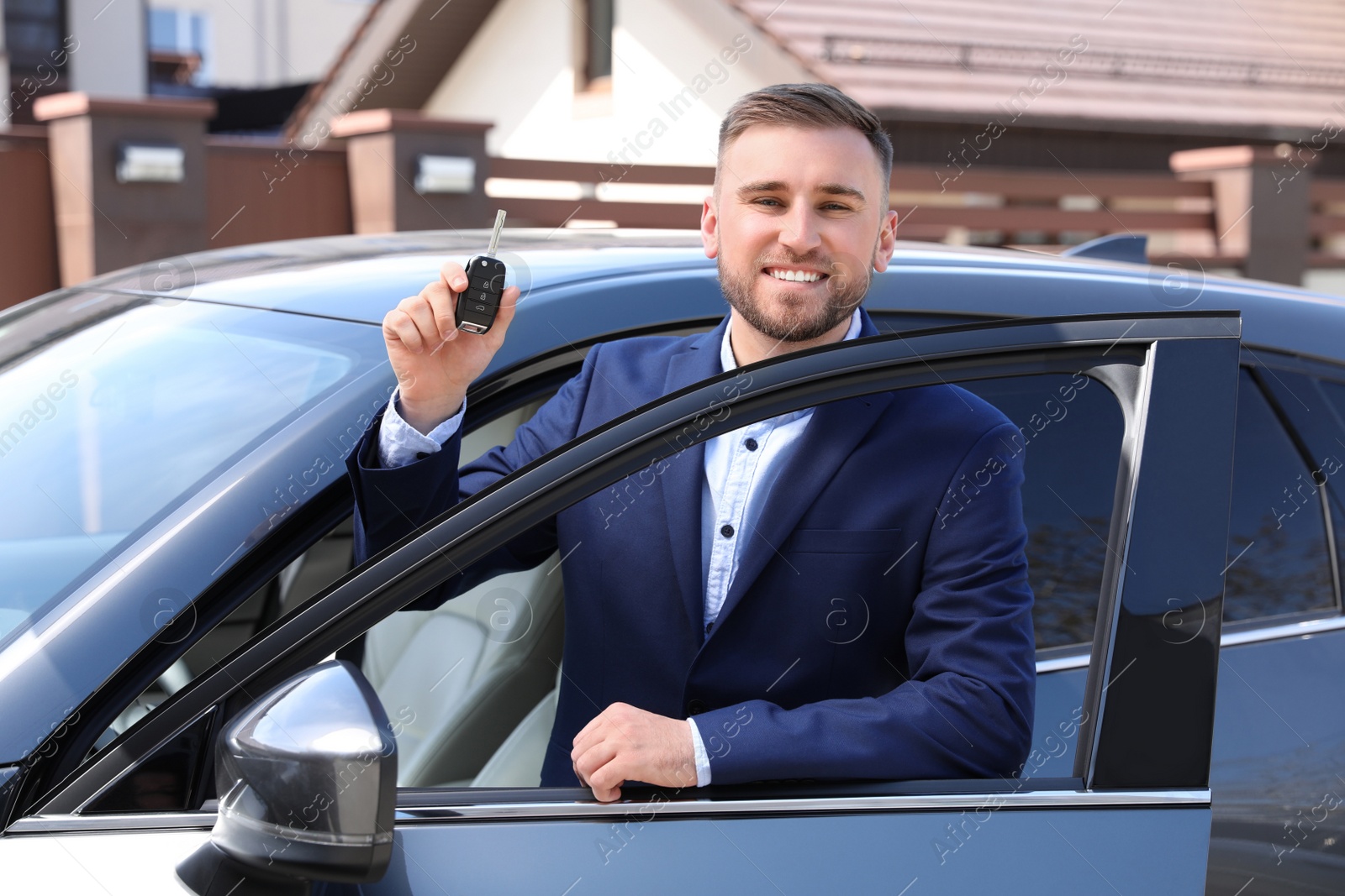 Photo of Young man with key near new car outdoors