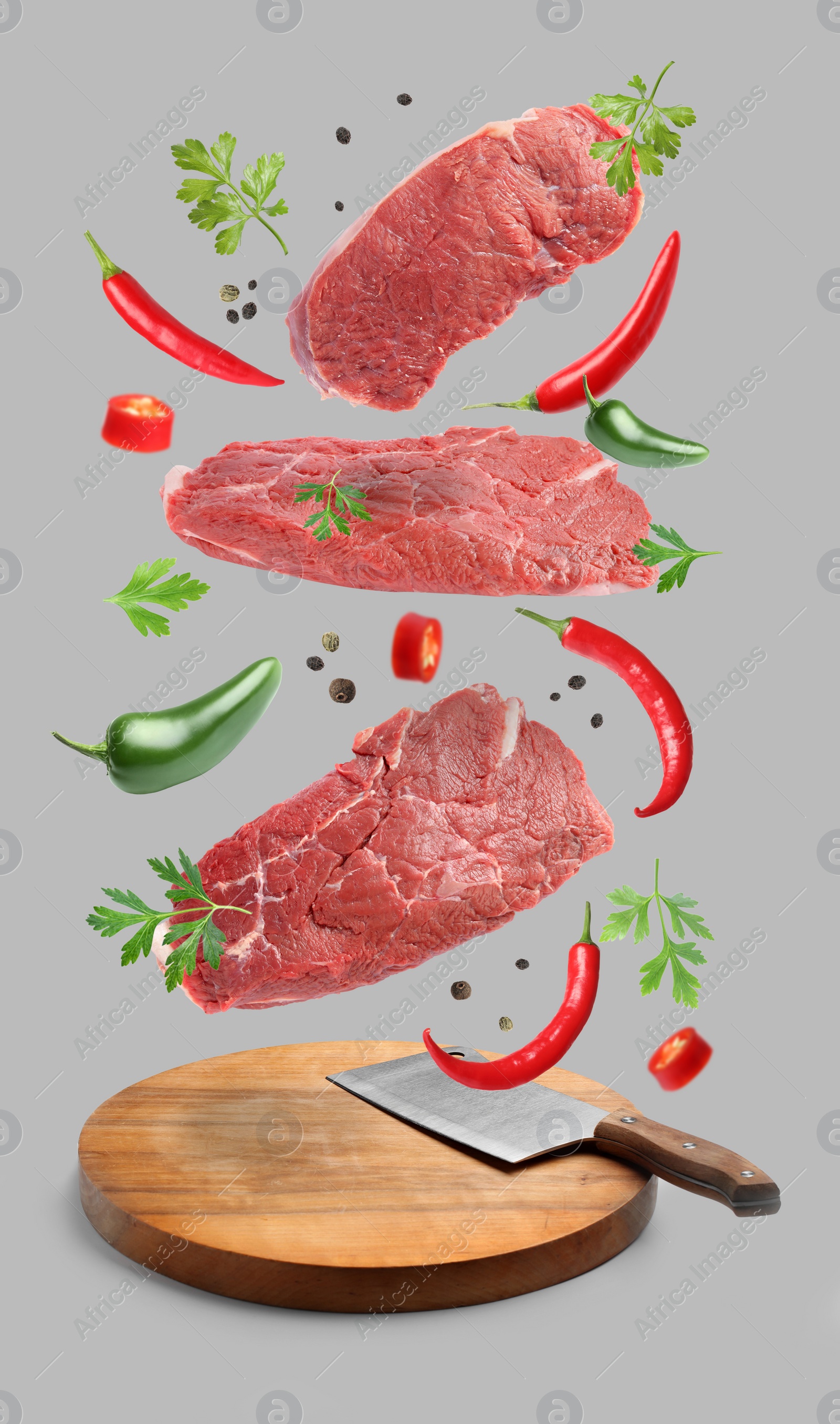 Image of Beef meat and different spices falling on grey background