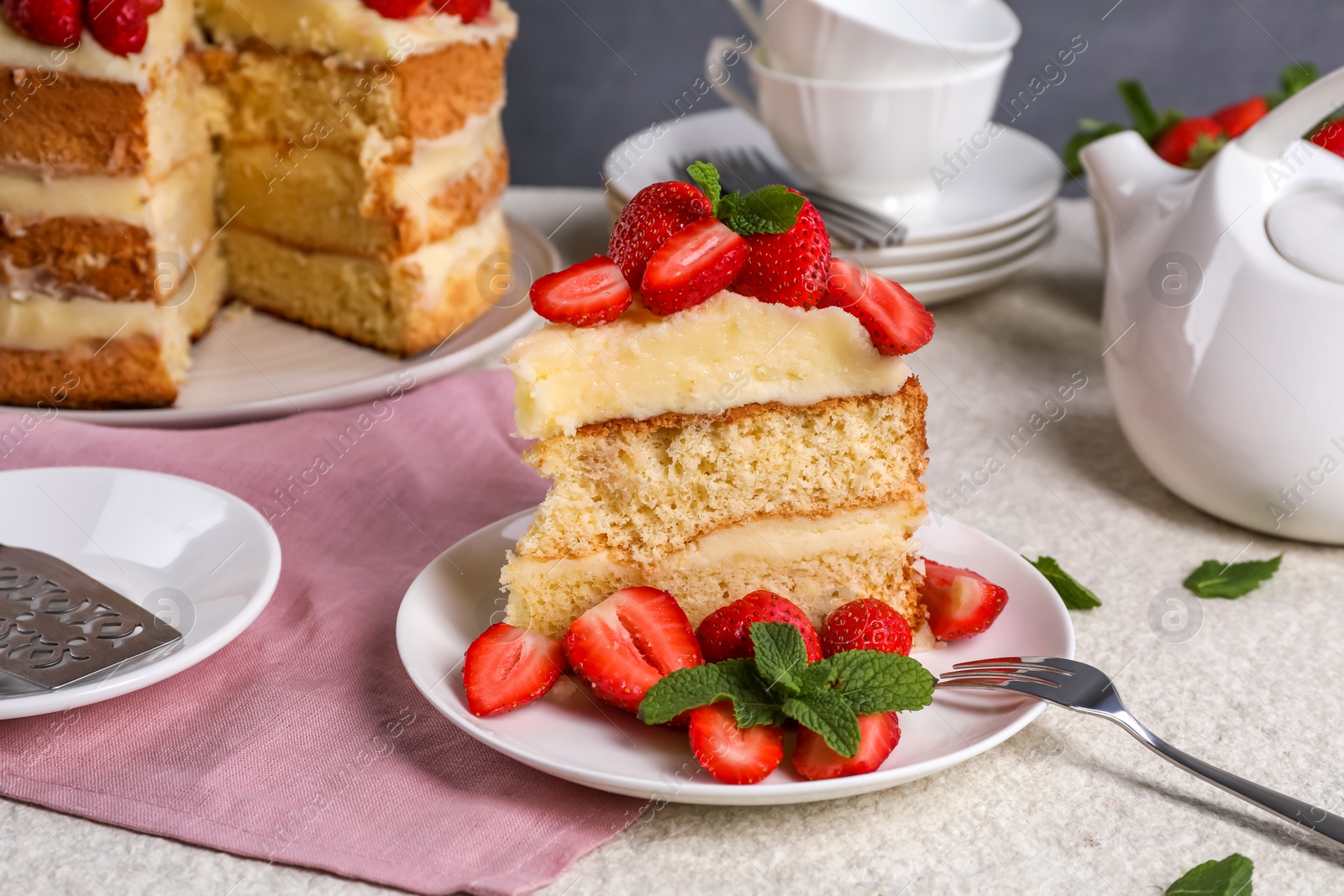 Photo of Piece of tasty cake with fresh strawberries and mint on white table