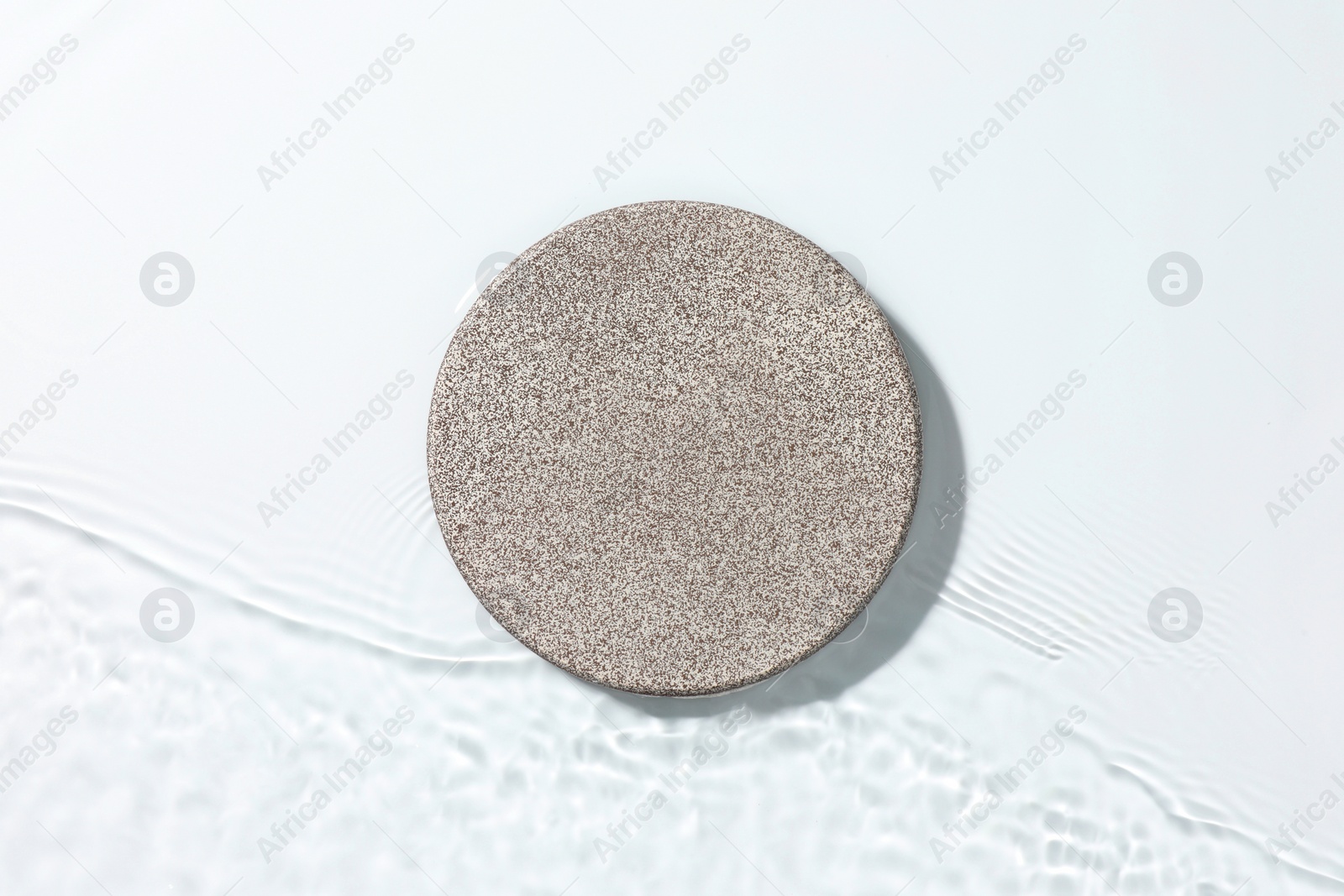 Photo of Presentation for product. Stone podium in water on white background, top view