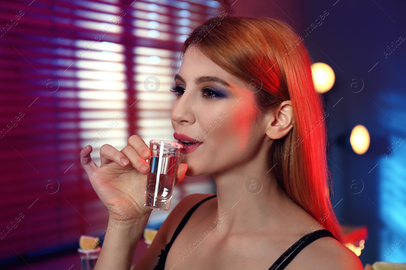 Photo of Young woman with Mexican Tequila shot in bar