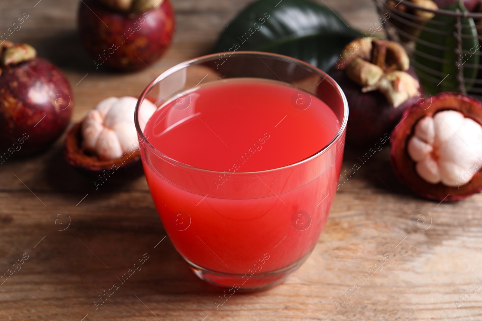Photo of Delicious mangosteen juice in glass on wooden table