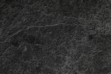 Photo of Texture of dark grey stone surface as background, closeup