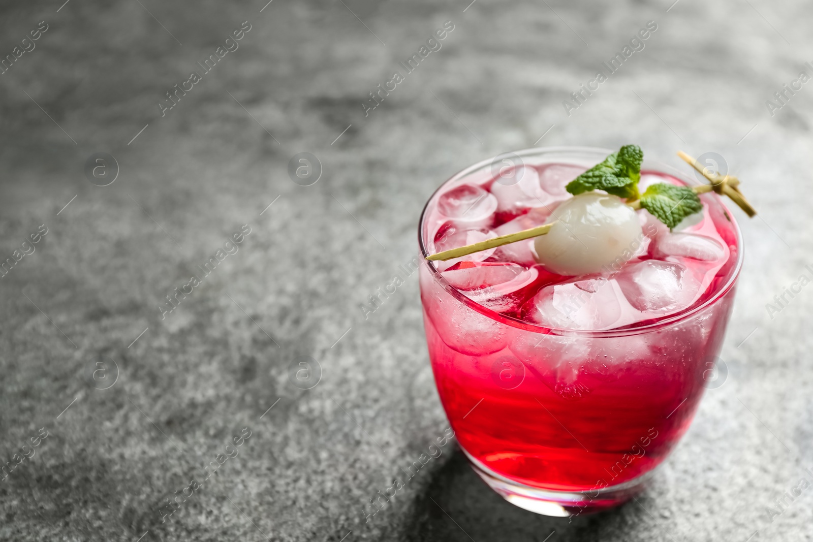 Photo of Delicious lychee cocktail with mint on grey table. Space for text
