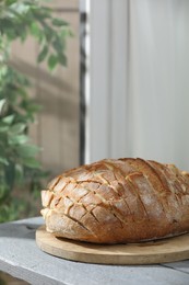 Photo of Freshly baked bread with tofu cheese on grey wooden table indoors