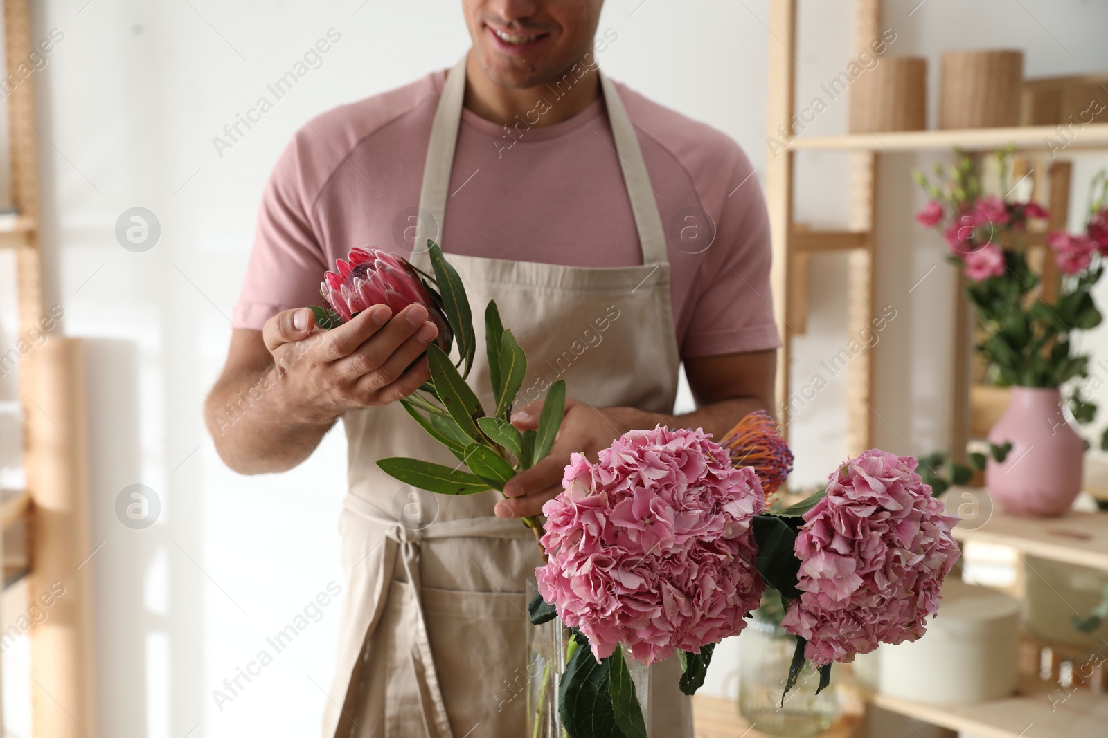 Photo of Florist with beautiful flowers in workshop, closeup