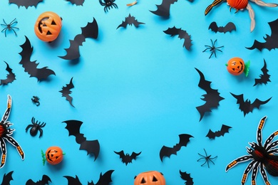 Frame made with Halloween decor elements on light blue background, flat lay. Space for text
