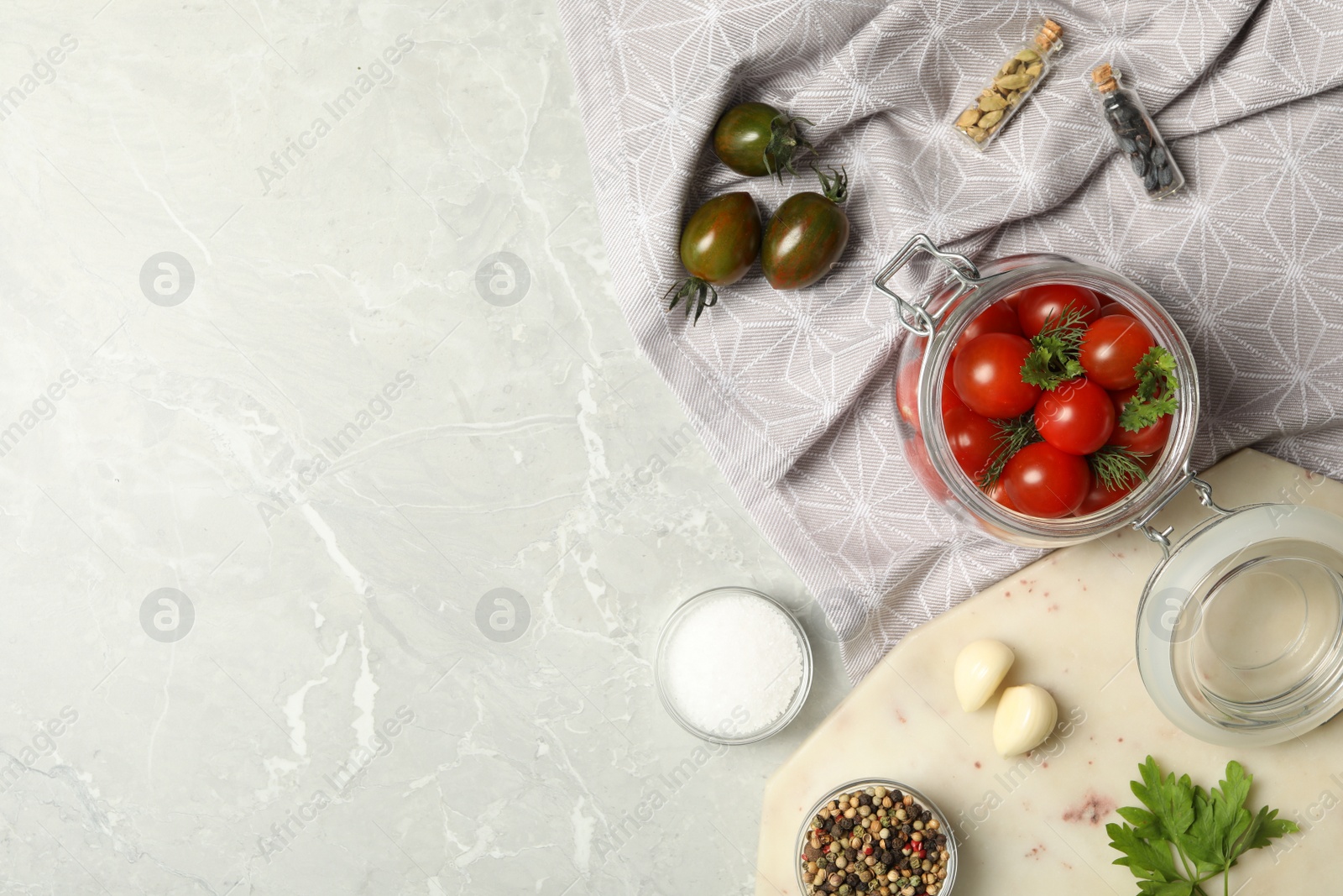 Photo of Pickling jar with fresh ripe cherry tomatoes and spices on grey table, flat lay. Space for text