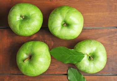 Fresh green apples on wooden background, top view