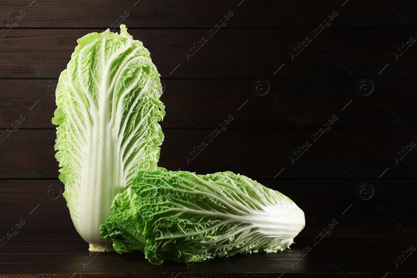 Photo of Fresh ripe Chinese cabbages on table against wooden background. Space for text