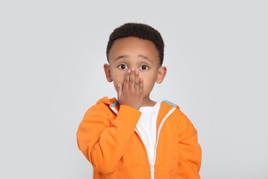 Photo of Emotional African-American boy on light grey background