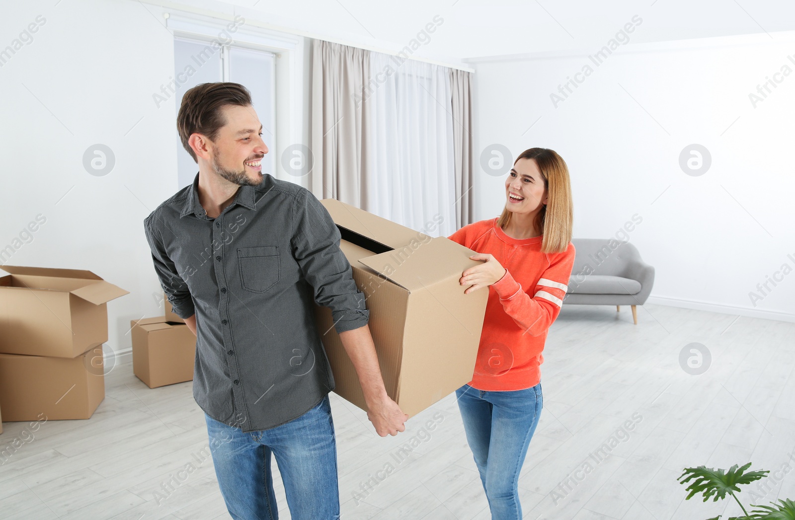 Photo of Couple with moving box in their new house
