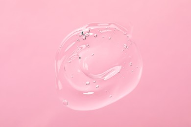 Sample of cleansing gel on light pink background, top view. Cosmetic product