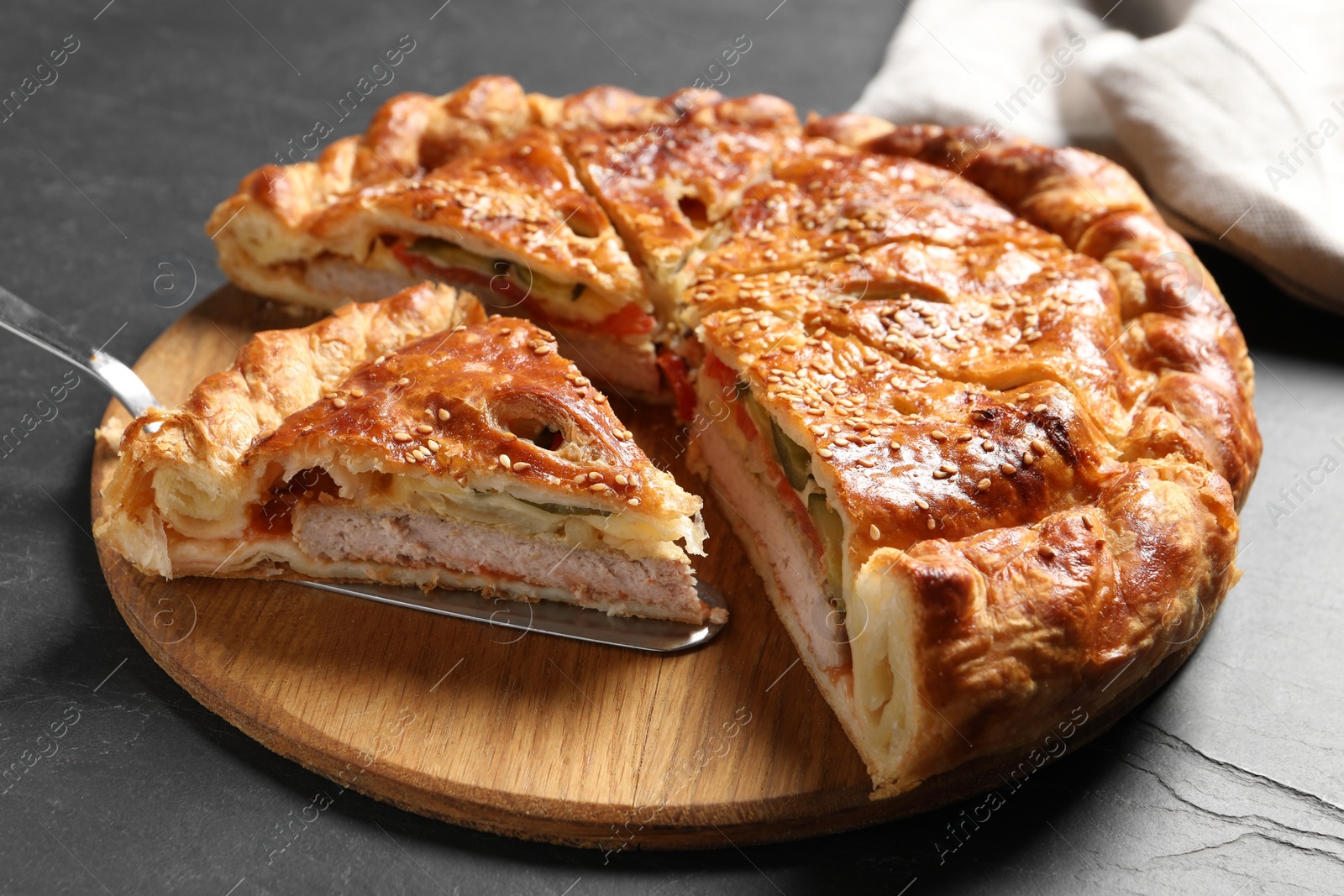 Photo of Cut delicious homemade pie and server on black table, closeup