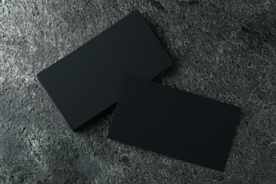 Blank black business cards on grey table, flat lay. Mockup for design