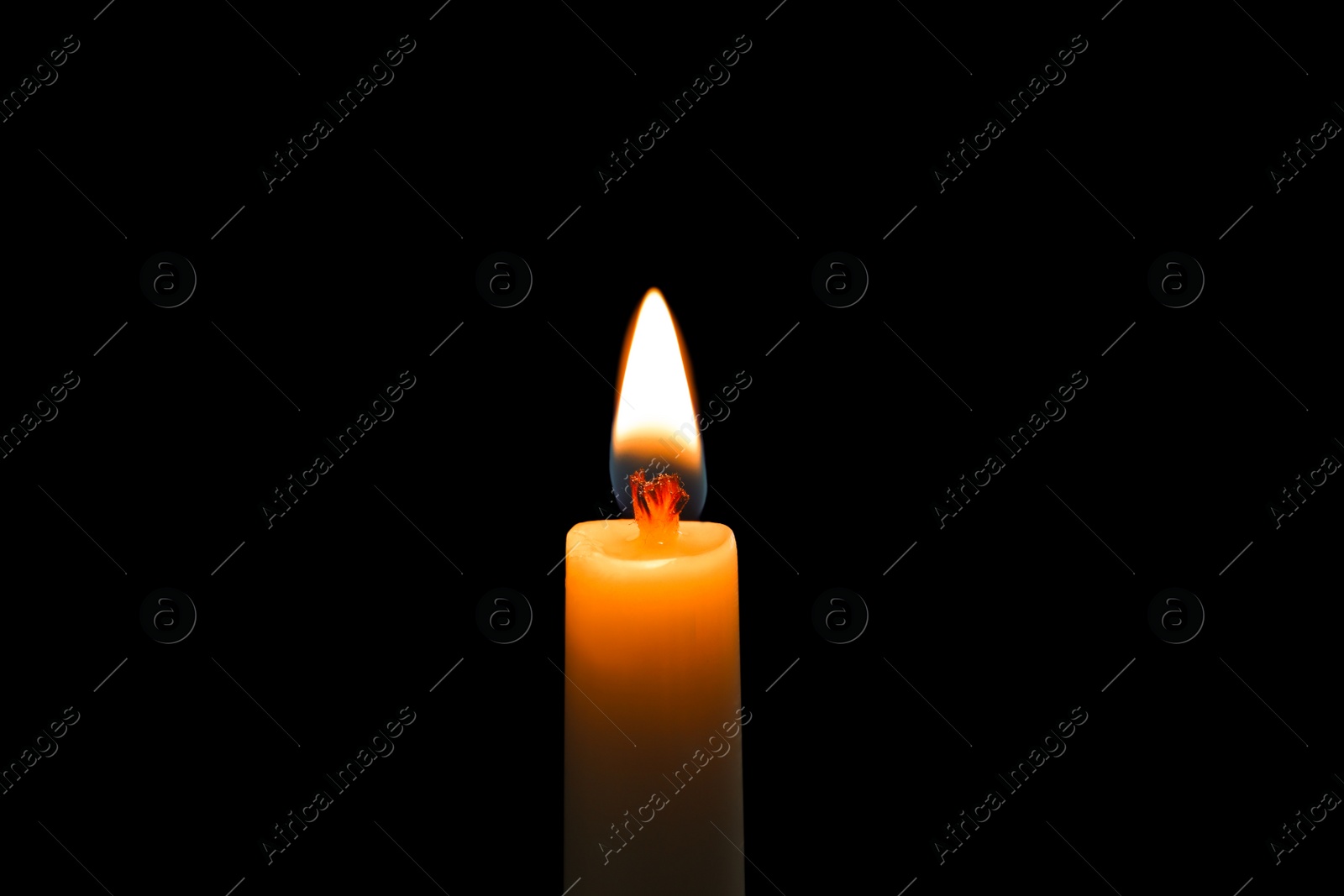 Photo of Wax candle burning on black background