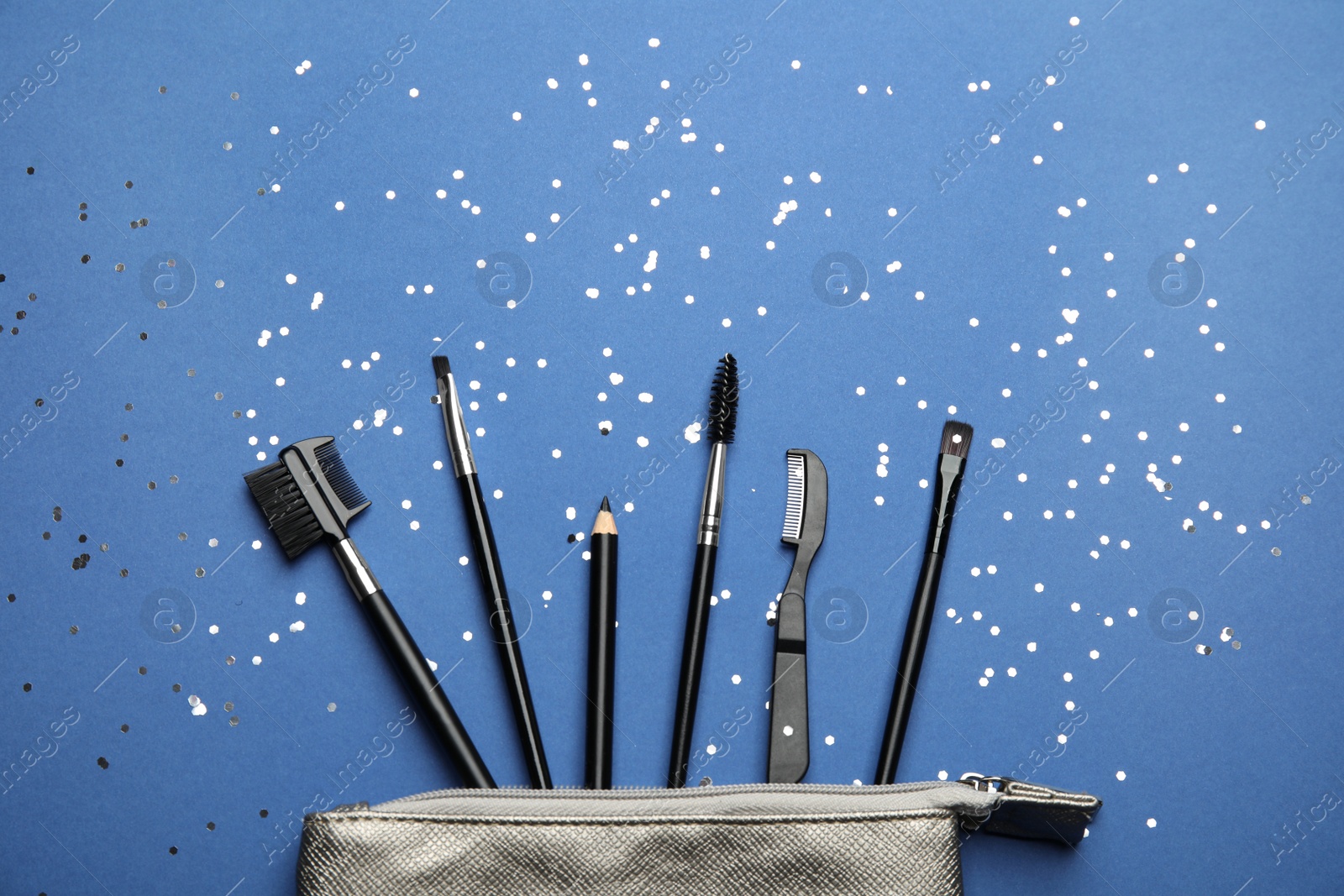 Photo of Flat lay composition with professional eyebrow tools on blue background