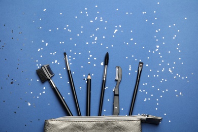 Photo of Flat lay composition with professional eyebrow tools on blue background