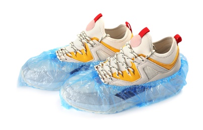 Photo of Pair of sneakers in medical blue covers on white background