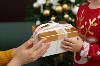 Photo of Mother and daughter with gift box at home, closeup. Christmas celebration
