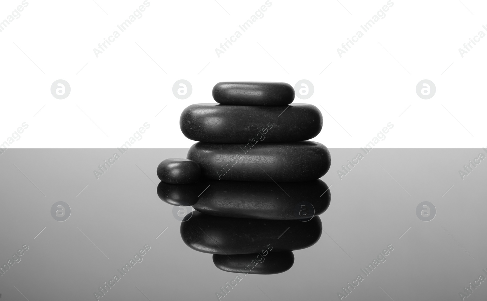 Photo of Stack of spa stones on mirror surface