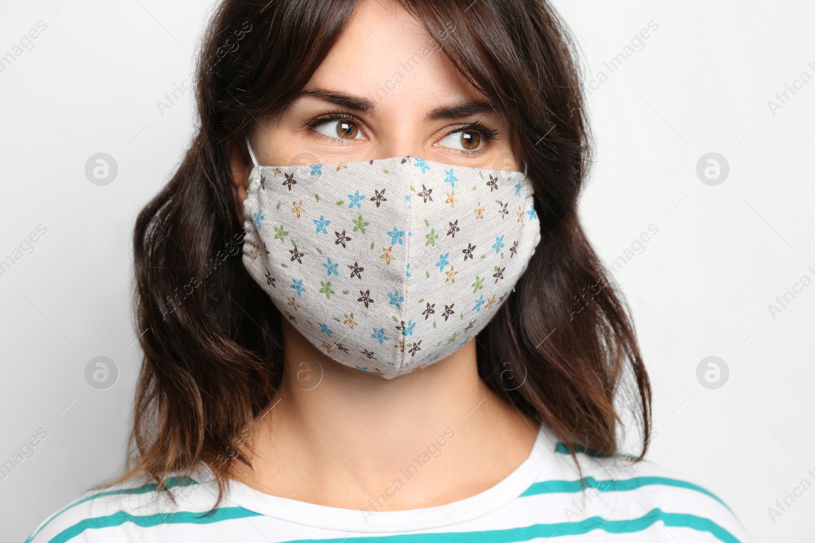 Photo of Young woman in protective face mask on light background, closeup