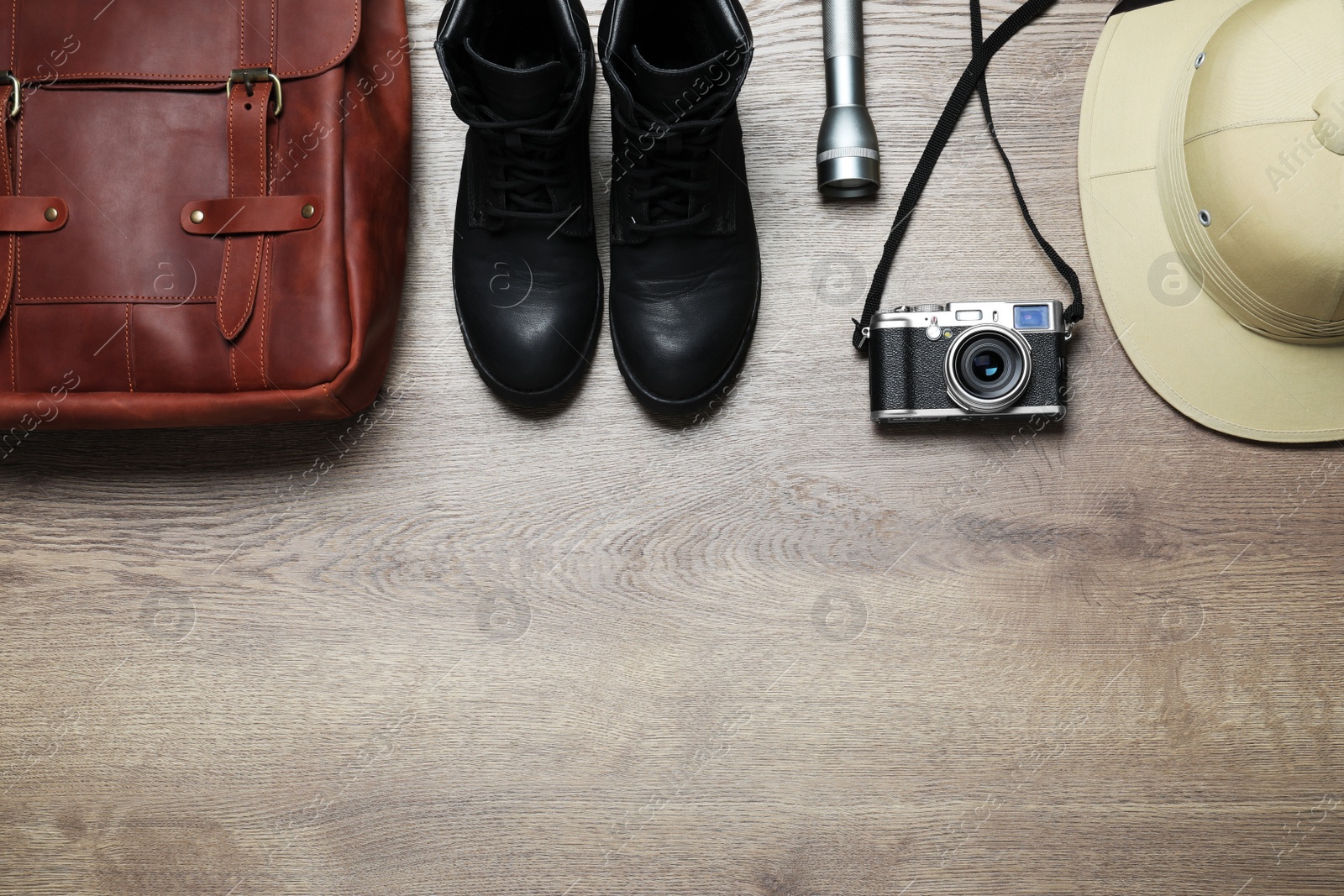 Photo of Flat lay composition with different safari accessories on wooden background. Space for text