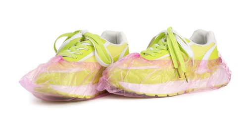 Sneakers in pink shoe covers isolated on white