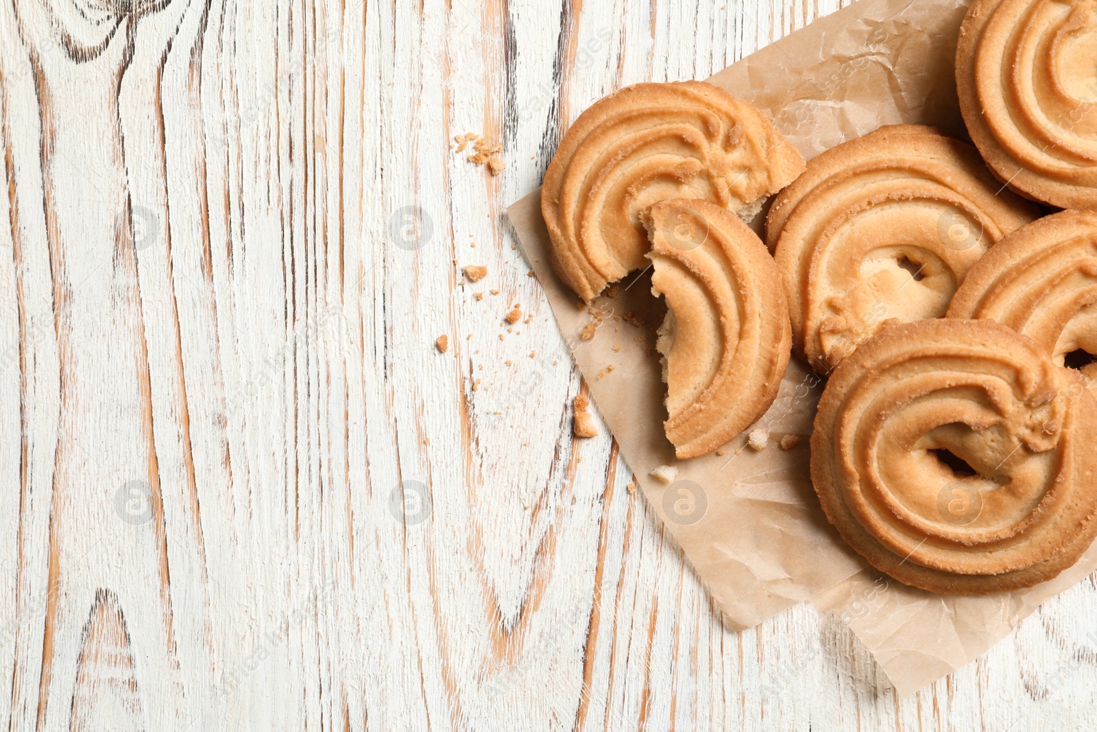 Photo of Tasty Danish butter cookies on wooden background, top view with space for text