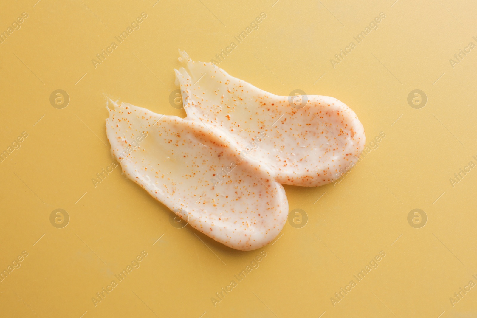 Photo of Sample of natural scrub on dark yellow, top view