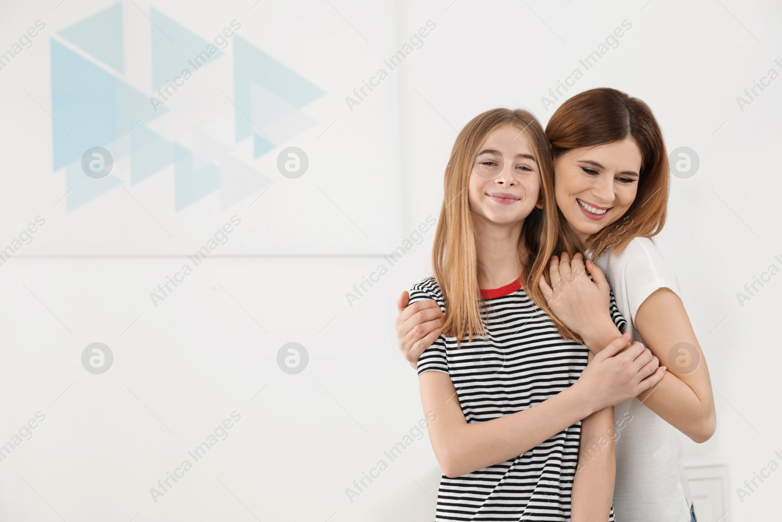 Photo of Happy mother hugging her teenager daughter at home