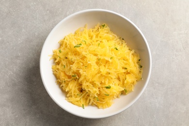 Photo of Bowl with cooked spaghetti squash on table, top view