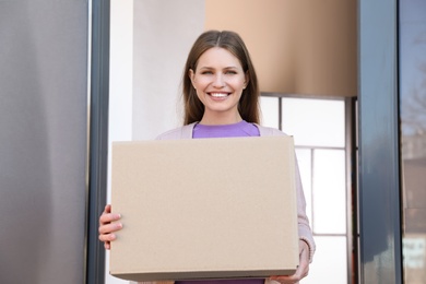 Portrait of smiling woman with parcel at door, mockup for design. Delivery service