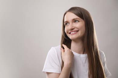 Portrait of beautiful woman on gray background, space for text