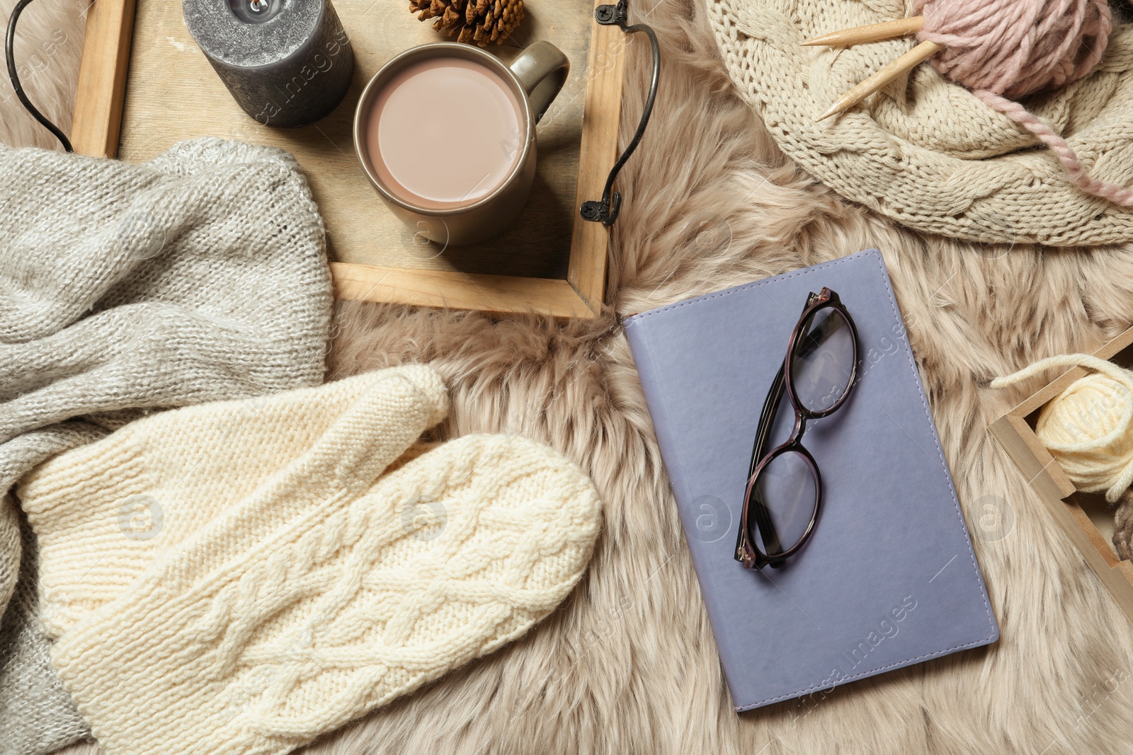 Photo of Flat lay composition with book, wool balls and cup of coffee on fuzzy rug