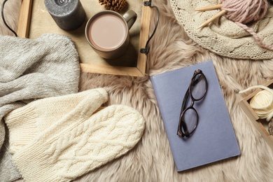 Photo of Flat lay composition with book, wool balls and cup of coffee on fuzzy rug