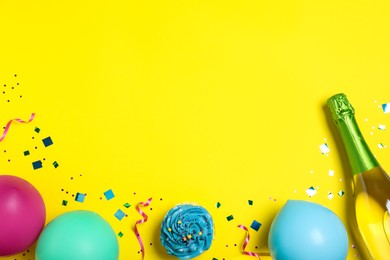Photo of Flat lay composition with birthday decor and bottle of sparkling wine on yellow background, space for text