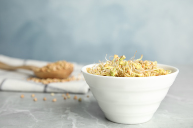 Bowl with sprouted green buckwheat on light grey table