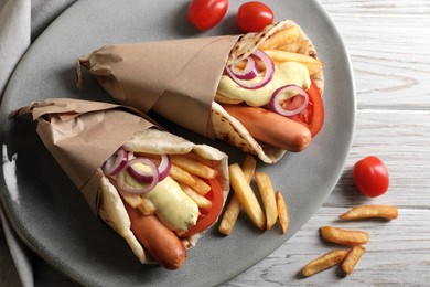 Photo of Delicious pita wrap with sausages, vegetables and potato fries on white wooden table, flat lay