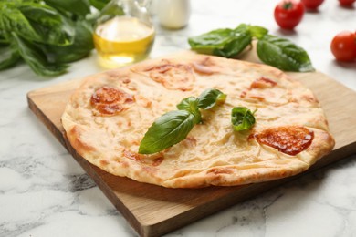 Delicious khachapuri with cheese on white marble table, closeup