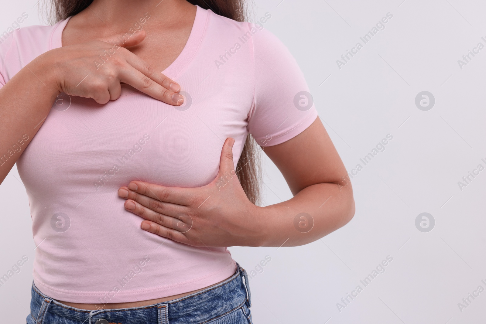 Photo of Woman doing breast self-examination on white background, closeup. Space for text