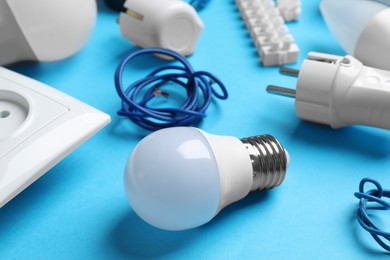 Photo of Set of electrician's accessories on light blue background